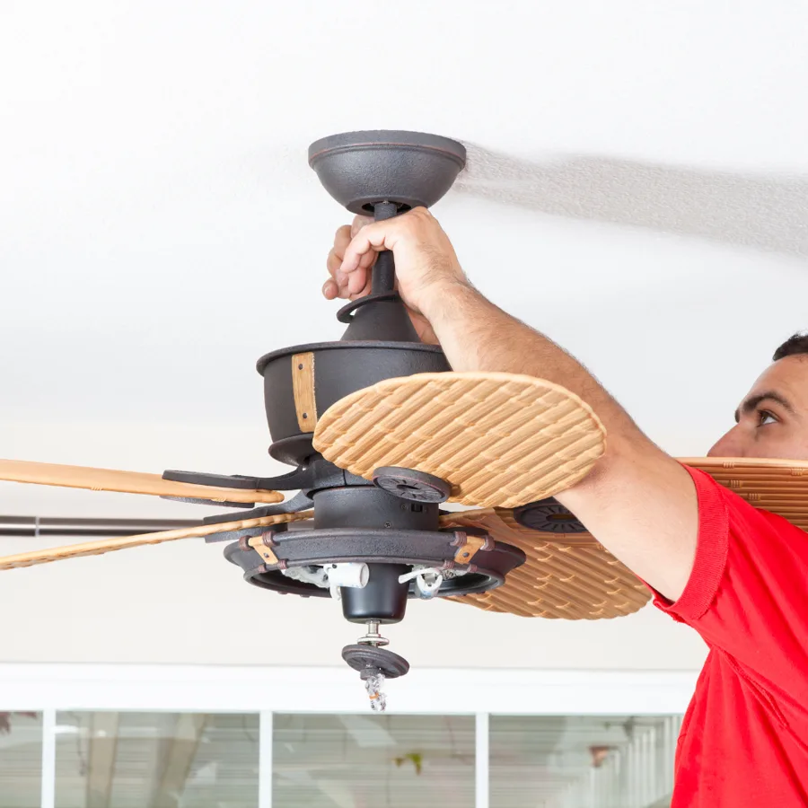 Technician mounting a ceiling fan canopy to a ceiling box
