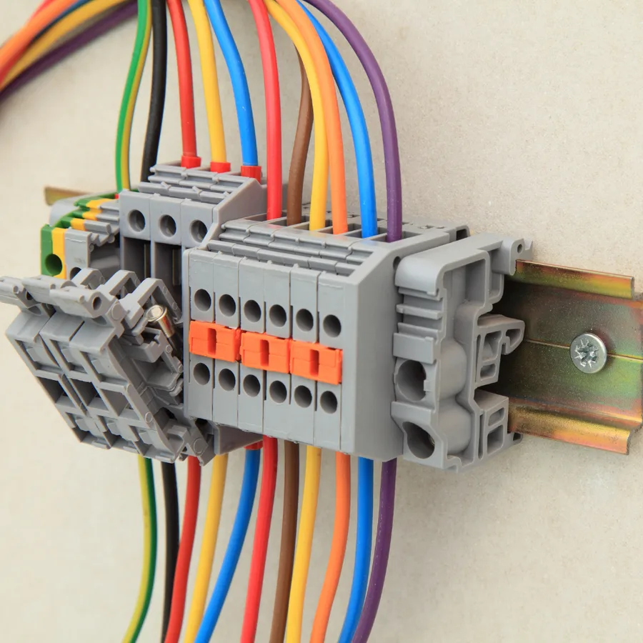 Color-coded circuit conductors landed on a din-rail terminal block inside electrical equipment