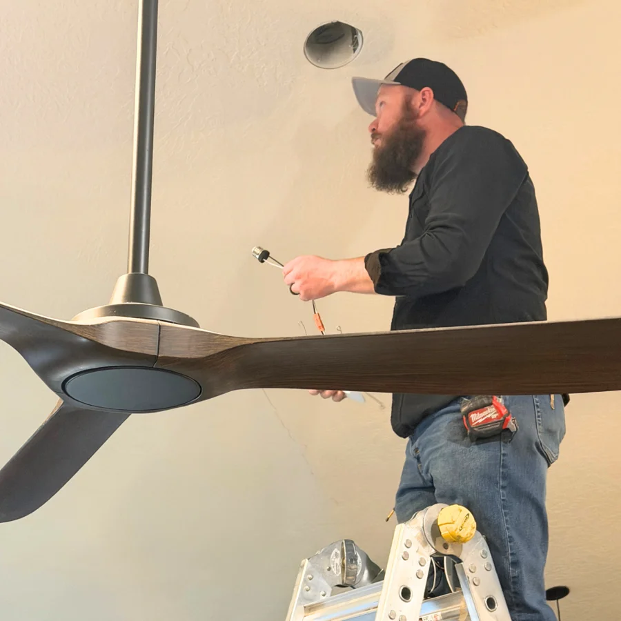 Electrician installing a ceiling fan
