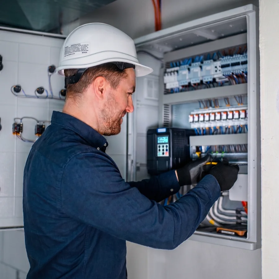 Electrician working inside a commercial electrical panel